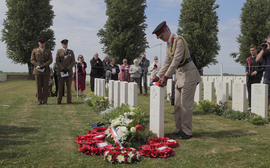 Colonel Howard Wilkinson, Military Attache, British Embassy Paris, puts a French flag on the grave of Second Lieutnant Osmund Bartle Wordsworth during a Rededication Service, in the cemetery of Ecoust-Saint-Mein, northern France, Tuesday, June. 21, 2022. Wordsworth was killed in action at the Battle of Arras on April 2, 1917.