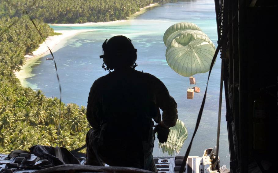 Staff Sgt. William Jenkins, a loadmaster with the 36th Expeditionary Airlift Squadron at Yokota Air Base, Japan, watches an Operation Christmas Drop bundles fall to Falalop, an island in the Federated States of Micronesia, Tuesday, Dec. 5, 2023.