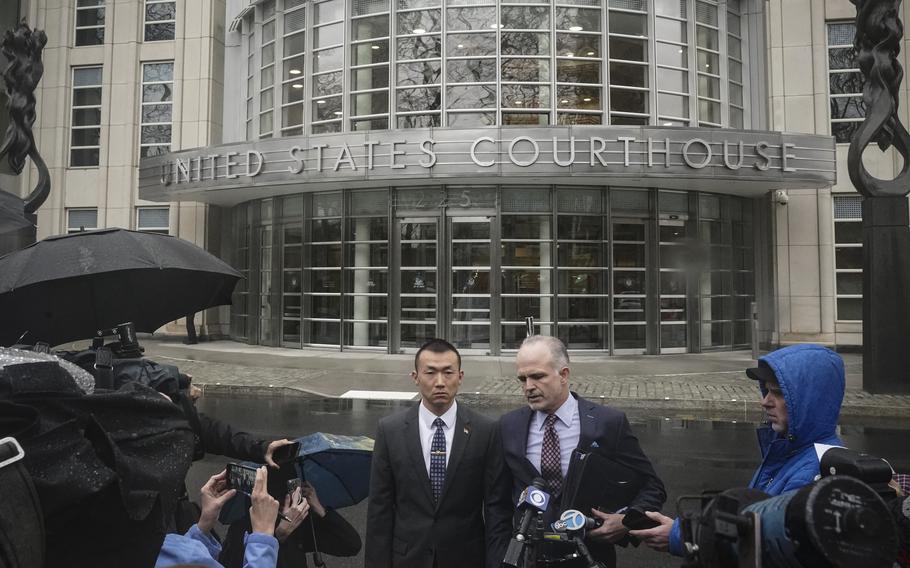 NYPD officer Baimadajie Angwang, center left, a naturalized U.S. citizen born in Tibet, and his attorney John Carman, center right, hold a press briefing outside Brooklyn's Federal court after a judge dismissed spy charges against him, Thursday Jan. 19, 2023, in New York. Federal prosecutors dropped charges against Angwang, who authorities had initially accused of spying on independence-minded Tibetans on behalf of the Chinese consulate in New York. 