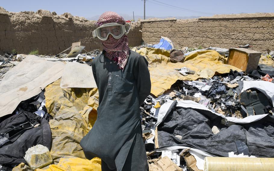 Mohammed Daoud, 14, wears U.S. military goggles as he scavenges trash left behind by U.S. and NATO troops as they pack up from Bagram Airfield, Afghanistan. 