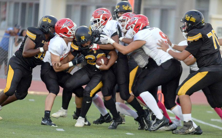 Kadena's Jeremiah Drummer gets bottled up by Nile C. Kinnick defenders.