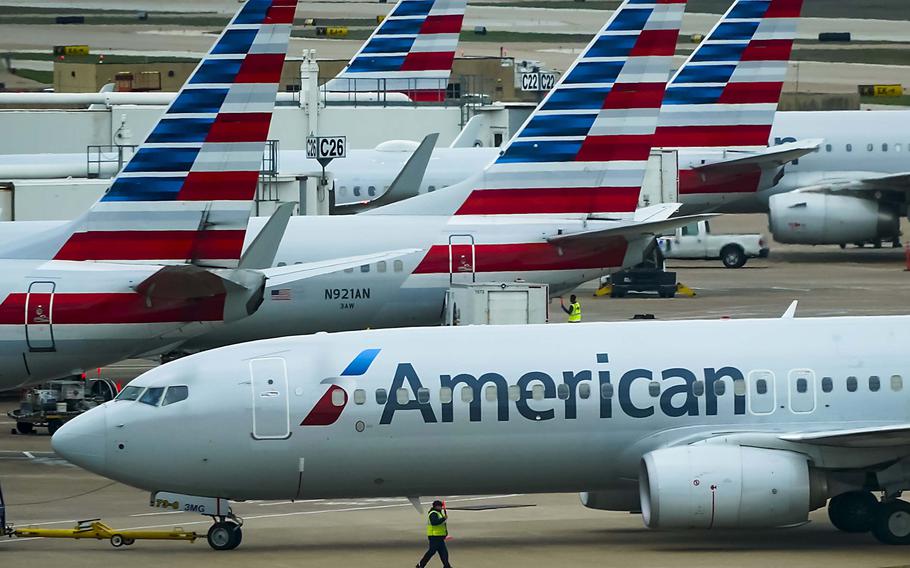An American Airlines plane pushes back from the gate at Dallas Fort Worth International Airport Terminal C. The airline recently added a checked bag charge for basic economy passengers for most international flights.