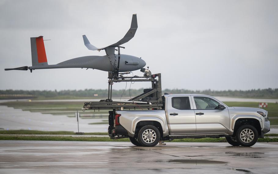 A large drone being carried in the back of a pickup truck.