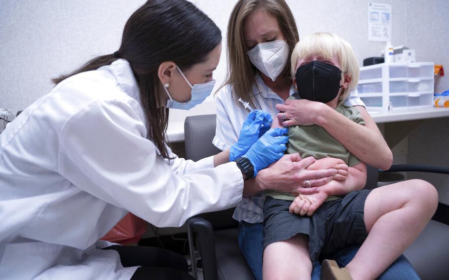 Pharmacist Kaitlin Harring, left, administers a Moderna COVID-19 vaccination to three year-old Fletcher Pack, while he sits on the lap of his mother, McKenzie Pack, at Walgreens pharmacy on Monday, June 20, 2022, in Lexington, S.C.