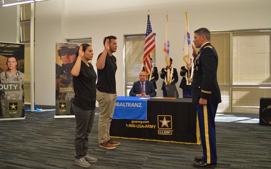 Lt. Col. David Clukey (right), commander, Phoenix Recruiting Battalion, conducts an oath of enlistment ceremony for two Phoenix future soldiers, following a Partnership for Youth Success (PaYS) program partnership signing event agreement between the U.S. Army and GlobalTranz, March 30, GlobalTranz Headquarters, Scottsdale, Arizona. (Photo by Alun Thomas, USAREC Public Affairs)