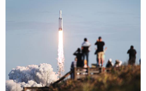 People watch as the SpaceX Falcon Heavy rocket lifts off from launch pad 39A at NASA’s Kennedy Space Center on April 11, 2019, in Titusville, Fla.