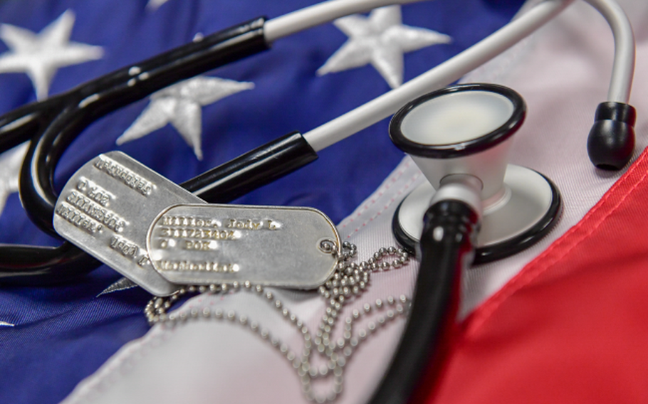 Dog tags and a stethoscope on top of an American flag.