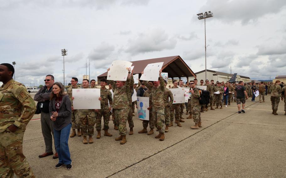 Airmen hold up posters in a group