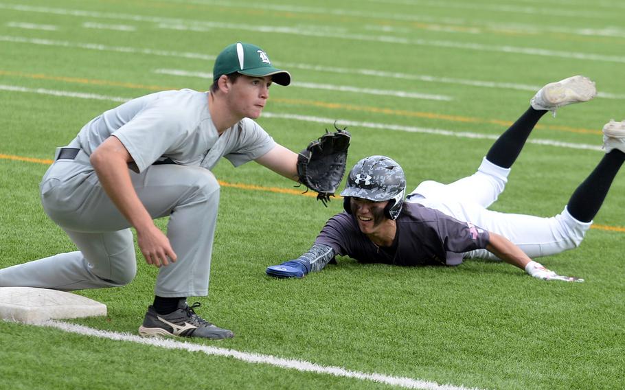 Kubasaki third baseman Lukas Gaines awaits the throw to tag out American School In Japan's Joey Schulz during Friday's inter-district baseball game. The Dragons edged the host Mustangs 2-1.