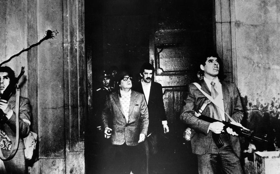 Armed guards watch out for attackers as Chile President Salvador Allende leaves the Moneda Presidential Palace during the military coup in which he was overthrown and killed in 1973. 