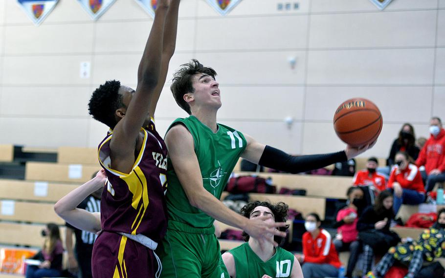 SHAPE’s Paulo Cuni gets past Vilseck’s Barkale Johnson to take a shot in the Spartans’ 47-39 loss to the Falcons in opening day action at the DODEA-Europe Division I championships in Ramstein, Germany, Feb. 23, 2022. 