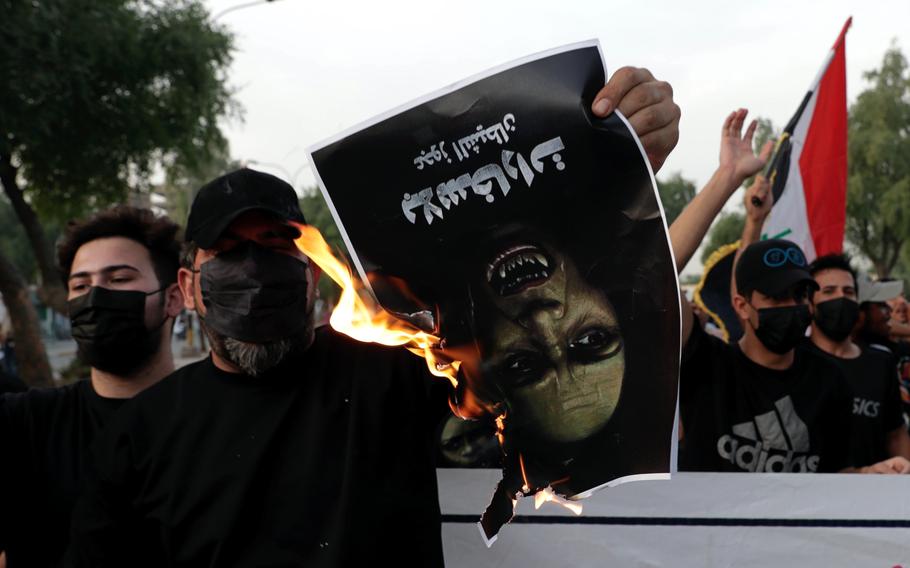 Protesters denounce election results and call for a manual recount of the Oct. 10 parliamentary vote as they burn a poster depicting the U.N. special representative to Iraq Jeanine Hennis-Plasschaert outside the heavily fortified Green Zone, in Baghdad, Iraq, Sunday, Oct. 31, 2021. Three weeks after Iraqis cast their votes, pro-Iran Shiite militias who emerged as the biggest losers are still rejecting the outcome of Iraq’s parliamentary election, thrusting the country into uncertainty and potential political crisis. 