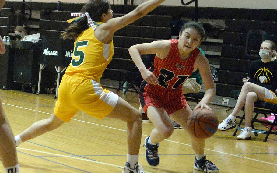 Nile C. Kinnick's Jasmine Pho looks to dribble past Robert D. Edgren's I'Lei Washington during Friday's semifinal in the DODEA-Japan girls basketball tournament. The Red Devils won 53-10 and will face E.J. King in Saturday's final.