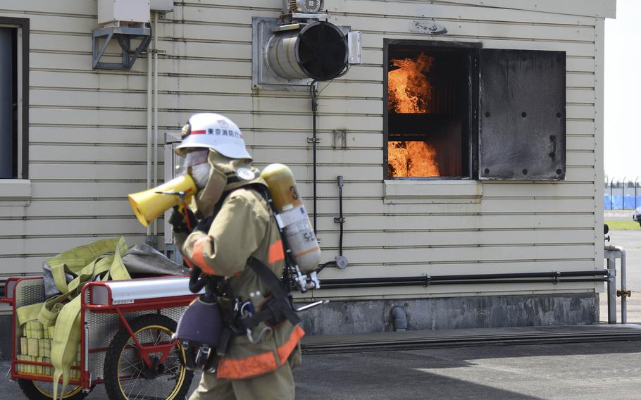 A Fussa city firefighter shouts instructions during a major accident response exercise at Yokota Air Base in western Tokyo, May 11, 2022.