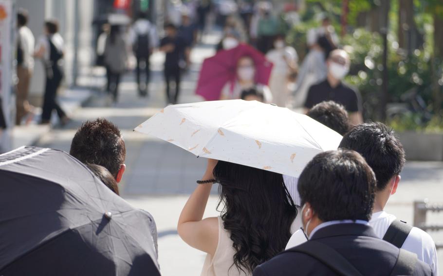 Umbrellas provide instant shade for pedestrians in central Tokyo on June 28, 2022. 