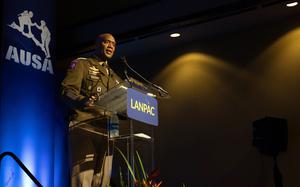 Xavier Brunson stands in uniform behind a podum that reads “LANPAC.”
