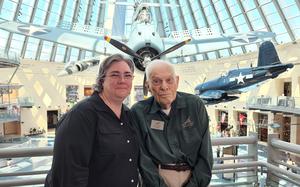 A woman and a man pose for a picture together in a museum