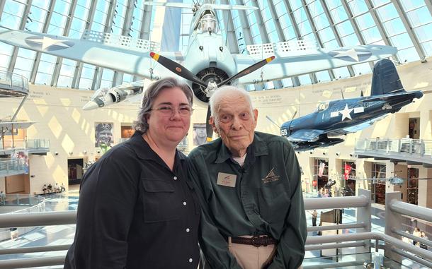 A woman and a man pose for a picture together in a museum