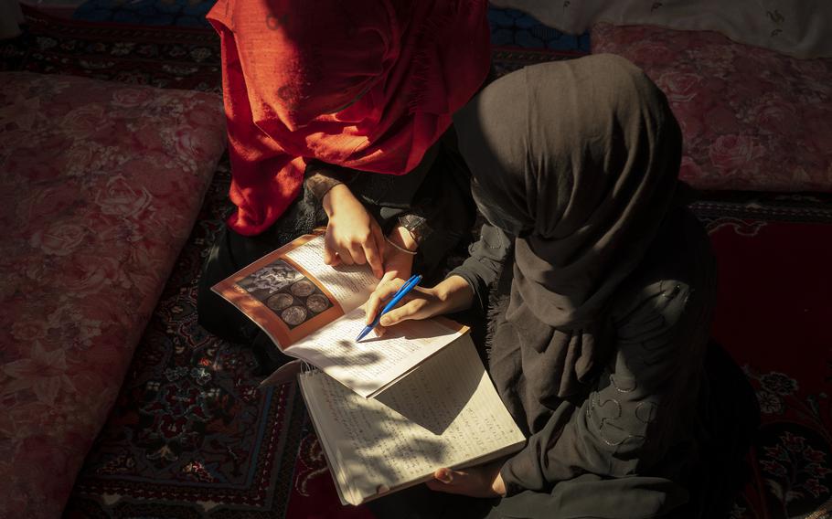 Before class begins, Masouda, right, reviews material with one of her students. 