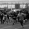 A black and white photo of people running on a race track.