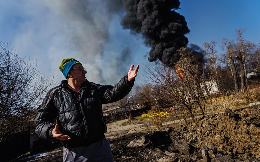 A man shows a fresh crater following Russian bombardment in Moskovskyi district in Kharkiv, Ukraine, on Friday, March 25, 2022.