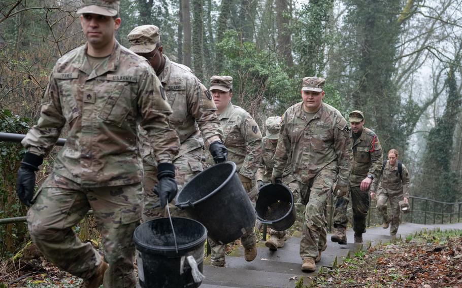 U.S. and German soldiers ascend about 250 steps before returning with buckets full of cement on Feb. 23, 2023. They were helping with repair work in St. Goar, Germany. 