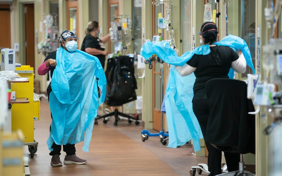 Nurses prepare to enter a COVID-19 patient's room inside an ICU unit at the Jennie Sealy Hospital on the Galveston campus of the University of Texas Medical Branch. 