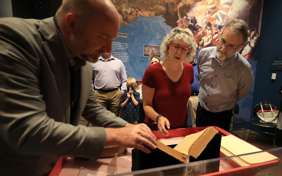 Chief historian and curator Philip Mead (left) of the Museum of the American Revolution, looks over the Claypoole family Bible with Aileen and David Edge inside the museum. The Edges donated the Bible to the museum. 