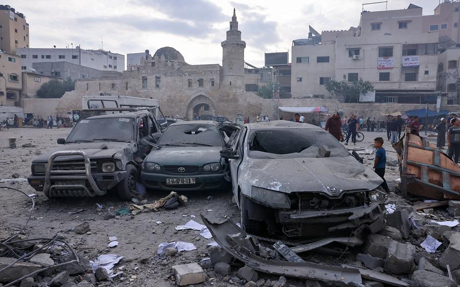 A Palestinian child inspects a damaged car in the city center of Khan Yunis in the southern Gaza Strip following overnight Israeli shelling,  Oct. 10, 2023.