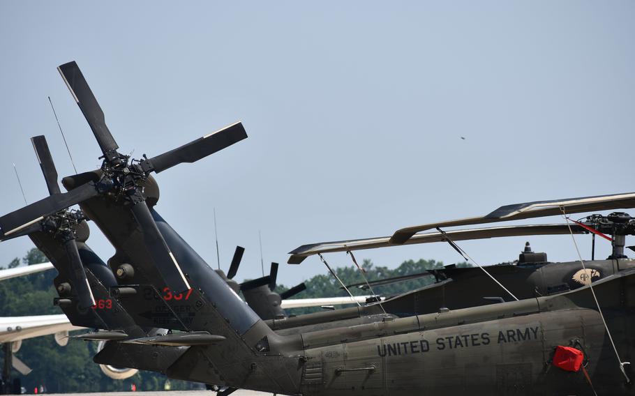 A line of black helicopter tails. United States Army is written on one.