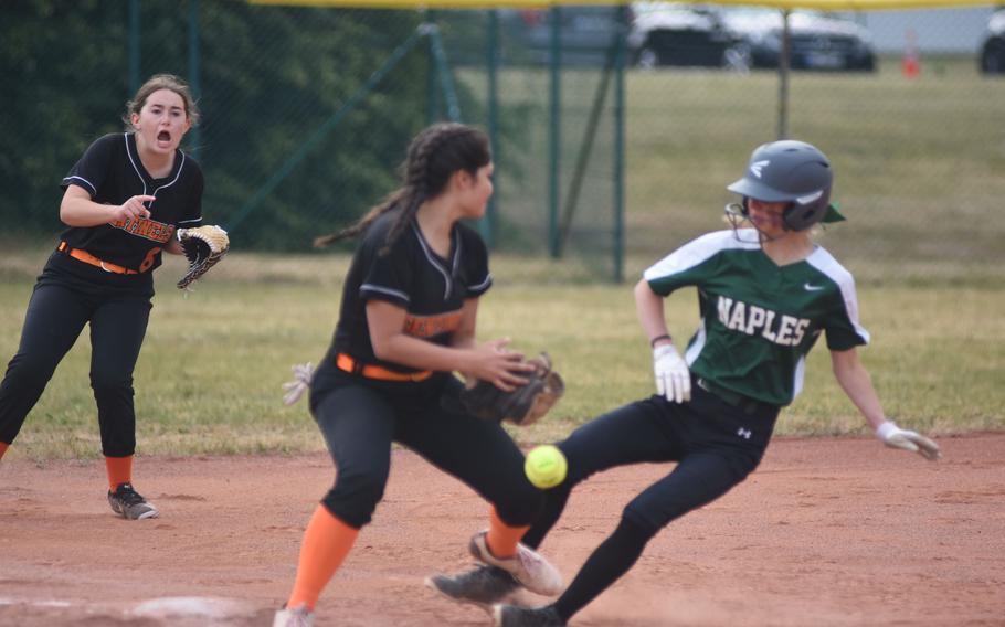 Spangdahlem's Sandrine Bennett yells encouragement to teammate Salma Stevinson as Naples' Carlyn Walker slides into third Wednesday, May 21, 2025, on the opening day of the DODEA-Europe Division II/III softball championships at Ramstein Air Base, Germany.