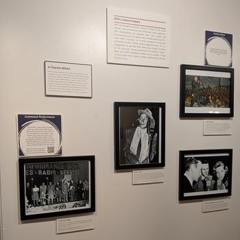 Framed photographs and placards adorn a wall.
