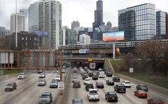 Traffic flows along Interstate 90 highway as a Metra suburban commuter train moves along an elevated track in Chicago on March 31, 2021. With upcoming data showing traffic deaths soaring, the Biden administration is steering $5 billion in federal aid to cities and localities to address the growing crisis by slowing down cars, carving out bike paths and wider sidewalks, and nudging commuters to public transit. 