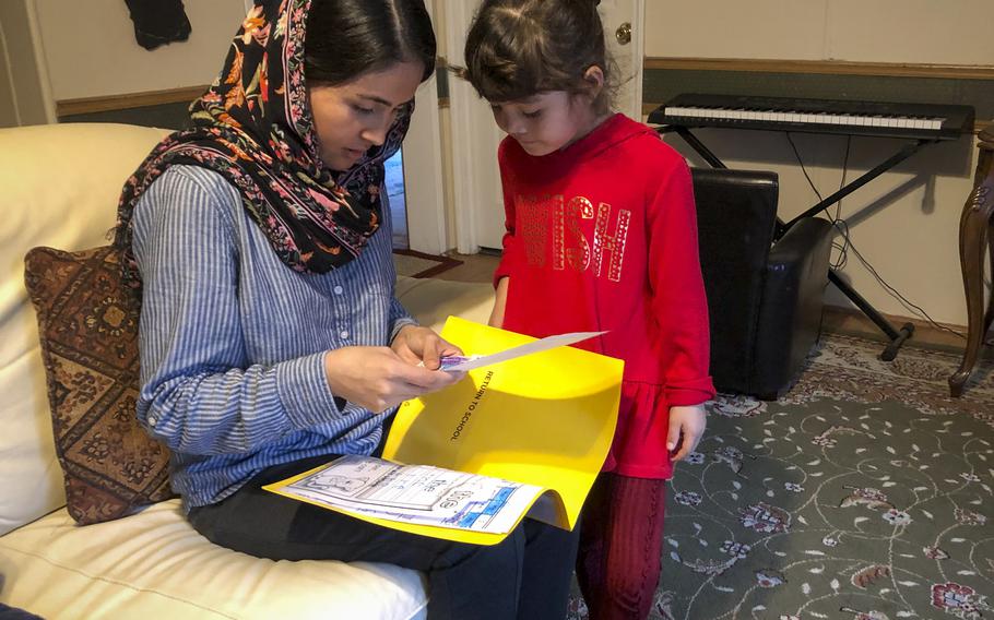 Rahima Asadi checks whether her daughter Zainab, 5, has homework at their home in the suburbs of Atlantic City, N.J., Oct. 26, 2021.