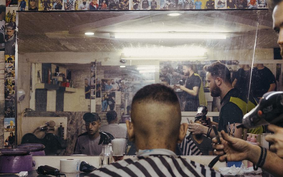 Young men at a barbershop in Balata refugee camp in Nablus. The shop is decorated with images of “martyrs” from Nablus and Jenin.