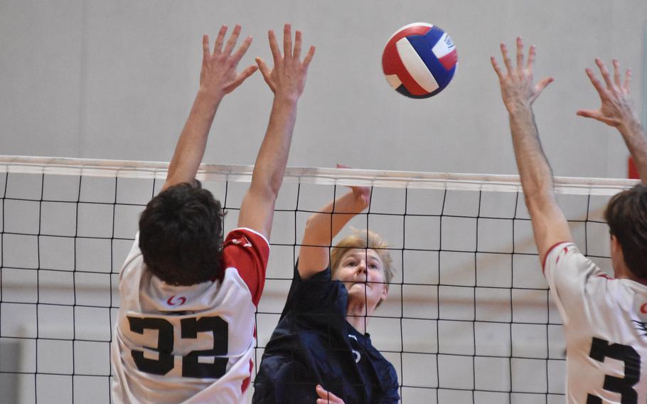 Black Forest Academy’s Timothy Sivonen tries to get the ball past the American Overseas School of Rome block of Aureliene Berthet, left, and Thomas Brown-Samper during the championship match of the DODEA-Europe boys volleyball tournament Saturday, Oct. 29, 2022.