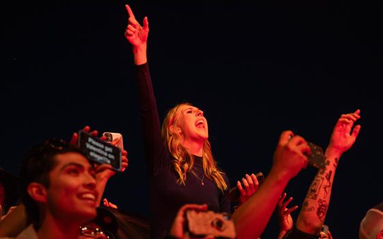 Concertgoers cheer during a live music performance.