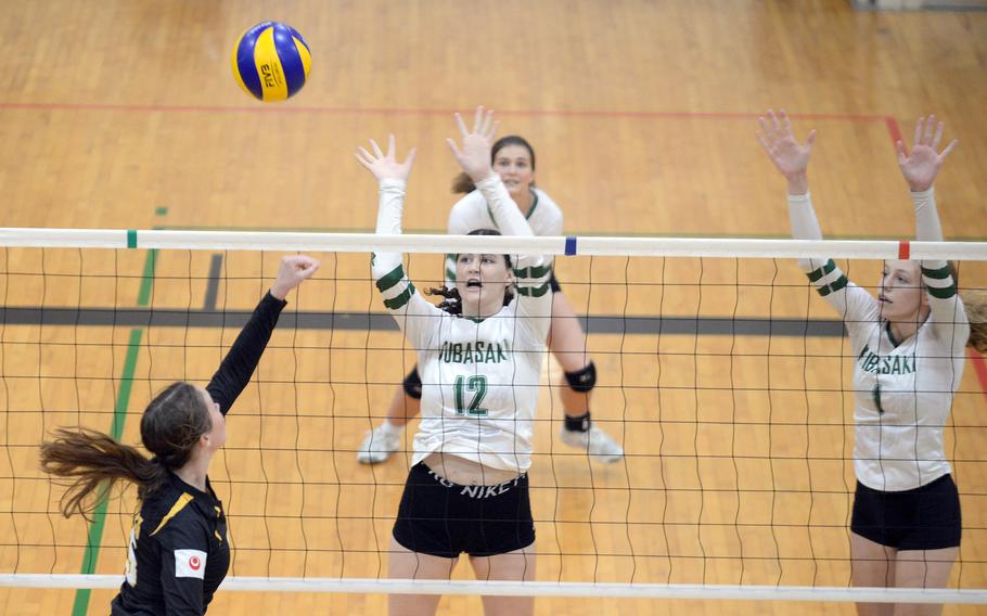 Kadena's Morgan Sayers plays the ball against Kubasaki's Olivia Schaffeld and Emma Leggio during Tuesday's Okinawa girls volleyball match. The Dragons won in four sets.