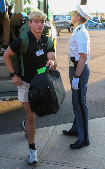 A new cadet steps off a bus.