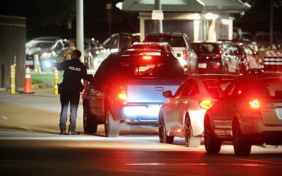 A police officer talks to a driver at a gate at Wright-Patterson Air Force Base, Ohio, near Dayton, Thursday, Sept. 9, 2021, The base was put on lockdown to investigate reports of a shooter on the campus, according to the airbase.