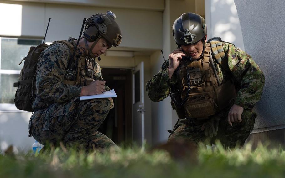 Marine Corps Capt. Eric Pak, left, and Japan Ground Self-Defense Force Master Sgt. Tomoya Tasaki call for air support during training at Camp Hansen, Okinawa, Dec. 15, 2023.