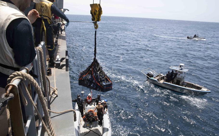 Sailors aboard the USS Hershel Woody Williams lower seized contraband into a rigid-hull inflatable boat for transport to Cape Verde authorities, April 6, 2022. U.S. military members aboard the ship helped seize an estimated $350 million in suspected cocaine hidden on a fishing vessel sailing off the west coast of Africa, U.S. Africa Command said.
