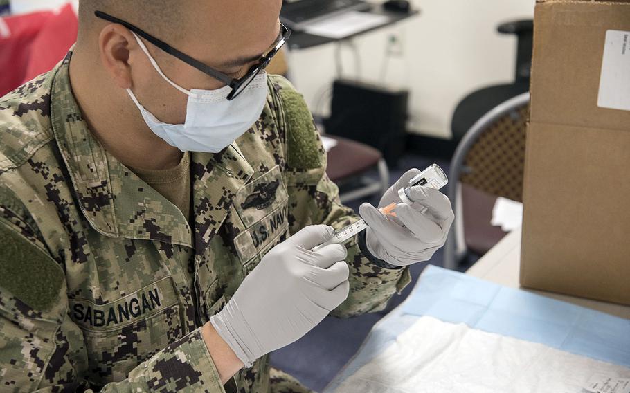 A sailor prepares a Moderna COVID-19 vaccine at Naval Air Facility Atsugi, Japan, May 7, 2021.