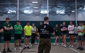 U.S. Marine Corps Sgt. Daniel Breuer, a production recruiter with Recruiting Sub-Station Quad Cities, Recruiting Station Milwaukee, 9th Marine Corps Recruiting District, leads Beckman-Dyersville Catholic high schoolers in strength and conditioning, at Beckman-Dyersville Catholic High School, Dyersville, IA, April 25, 2024. During the class students participated in Marine Corps style competitive workouts, learned about the importance of leadership, and given the chance to ask questions about Marine Corps benefits and opportunities. (U.S. Marine Corps photo by Cpl. Collette Hagen)