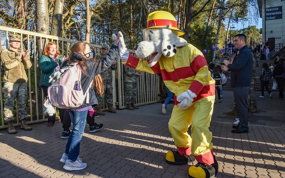 Sparky, the Ramstein Air Base fire department's mascot, gives a student at Ramstein Intermediate School a high-five on April 19, 2022, during the schools celebration for Month of the Military Child.

