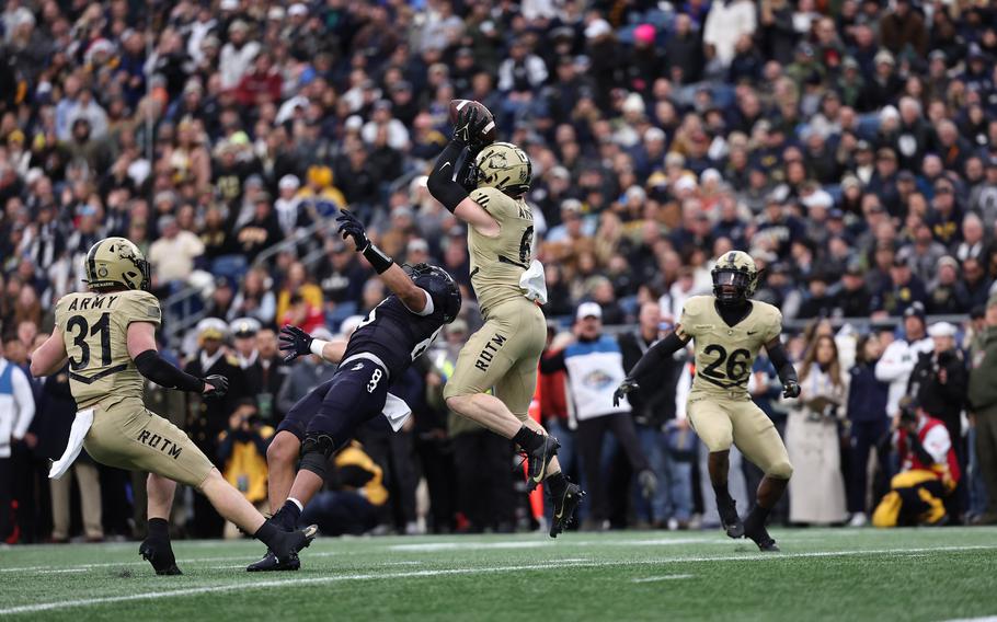 Army’s Max DiDomenico goes over Navy wide receiver Cody Howard to intercept a pass during the first quarter of an NCAA football game at Gillette Stadium Saturday, Dec. 9, 2023, in Foxborough, Mass.