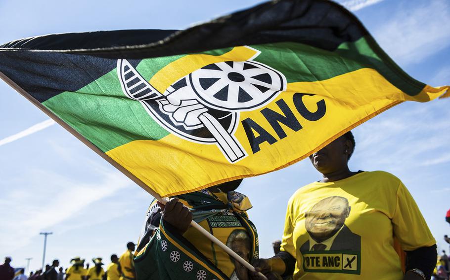 Supporters wearing party colors wave a flag during an African National Congress party campaign event in Bloemfontein, South Africa, on April 7, 2019.