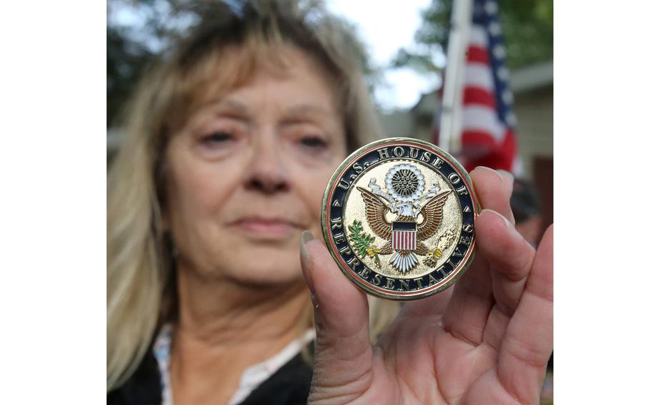 Susan O’Connor, a member of Blue Star Mothers, Rolling Thunder Chapter 2 and the Patriot Guard WWII, displays a challenge coin presented by the office of U.S. Rep. Anthony Gonzalez to WWII veteran Denver Conard of North Canton, Ohio.
