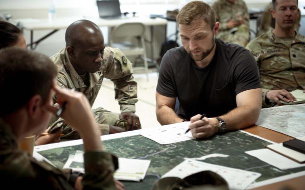 A man talks to uniformed troops.