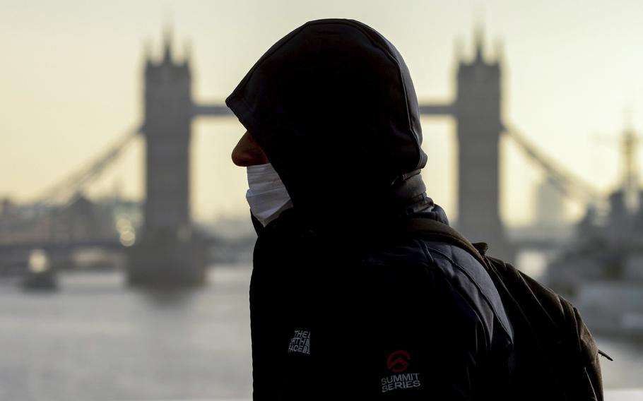 A commuter passes in view of Tower Bridge in London on Nov. 29, 2021. 